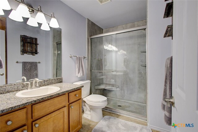 bathroom with walk in shower, vanity, and toilet