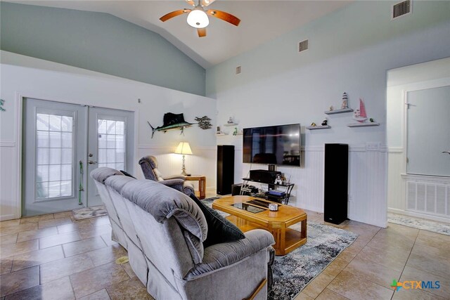 living room featuring ceiling fan, high vaulted ceiling, and french doors