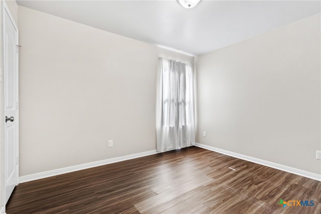 spare room with dark hardwood / wood-style flooring