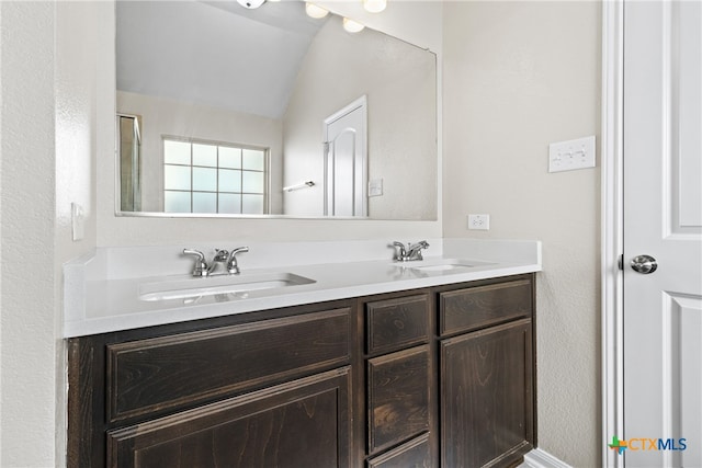 bathroom with vanity and lofted ceiling