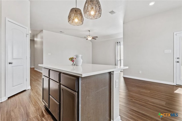 1910 Ashburn Dr, Temple, TX 76502 - kitchen featuring wood finished floors, light countertops, a ceiling fan, baseboards, and dark brown cabinets