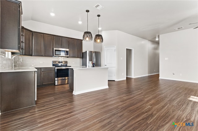 kitchen featuring dark hardwood / wood-style flooring, a center island, pendant lighting, and appliances with stainless steel finishes