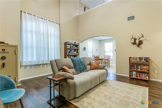 6707 Bayberry Dr, Killeen, TX 76542 - living room featuring arched walkways, a high ceiling, wood finished floors, and baseboards