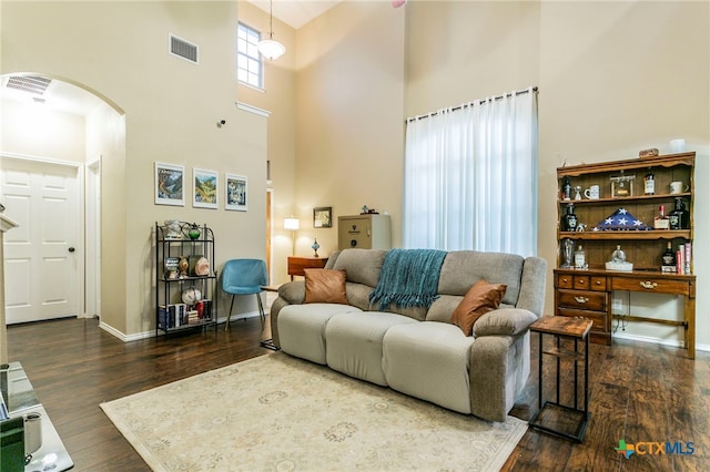 6707 Bayberry Dr, Killeen, TX 76542 - living room with arched walkways, a high ceiling, wood finished floors, and baseboards