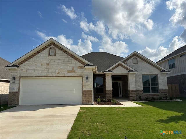 7217 Touchstone Dr, Temple, TX 76502 - french country inspired facade with concrete driveway, a front lawn, a garage, stone siding, and brick siding