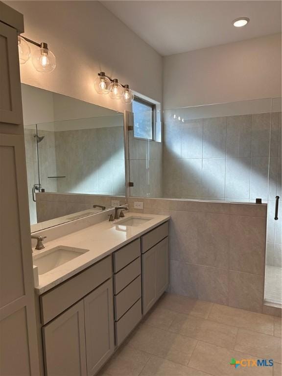 7217 Touchstone Dr, Temple, TX 76502 - bathroom featuring a tile shower, double vanity, tile walls, and tile patterned flooring