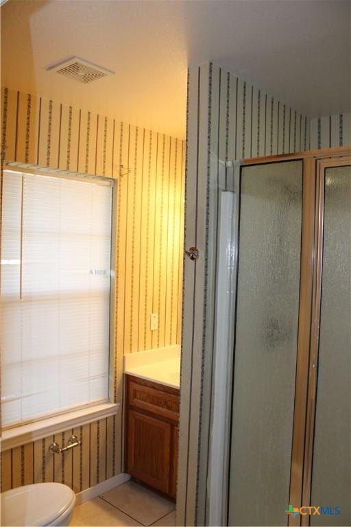 bathroom with tile patterned floors, vanity, and walk in shower