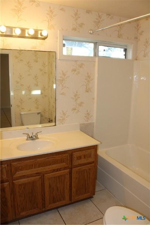 full bathroom featuring vanity, tile patterned flooring, washtub / shower combination, and toilet