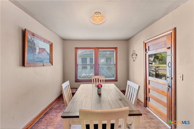 dining area with a wealth of natural light and wood-type flooring