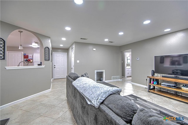 living area featuring arched walkways, visible vents, and recessed lighting