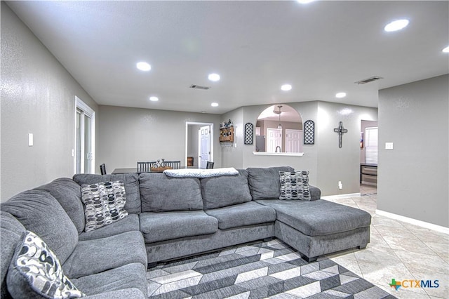 living room featuring baseboards, light tile patterned floors, visible vents, and recessed lighting