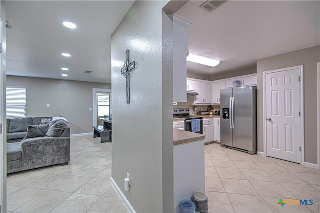 kitchen with light tile patterned floors, visible vents, white cabinets, appliances with stainless steel finishes, and open floor plan