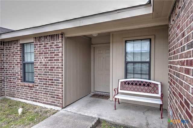 view of exterior entry with brick siding