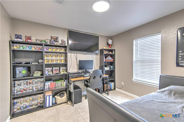 tiled bedroom featuring baseboards