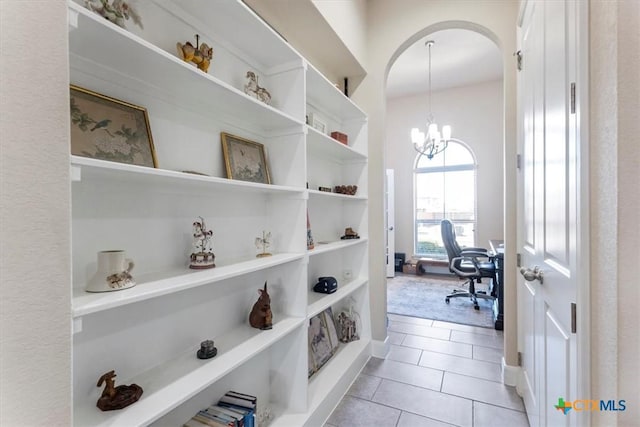 702 Old Settlers Dr, San Marcos, TX 78666 - corridor with light tile patterned floors, arched walkways, and a notable chandelier