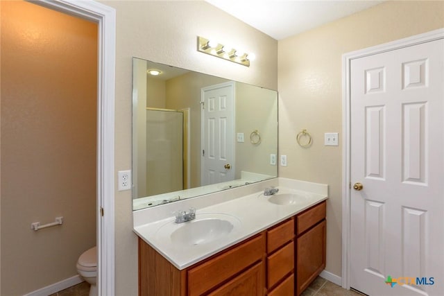 bathroom featuring tile patterned flooring, vanity, toilet, and a shower with shower door