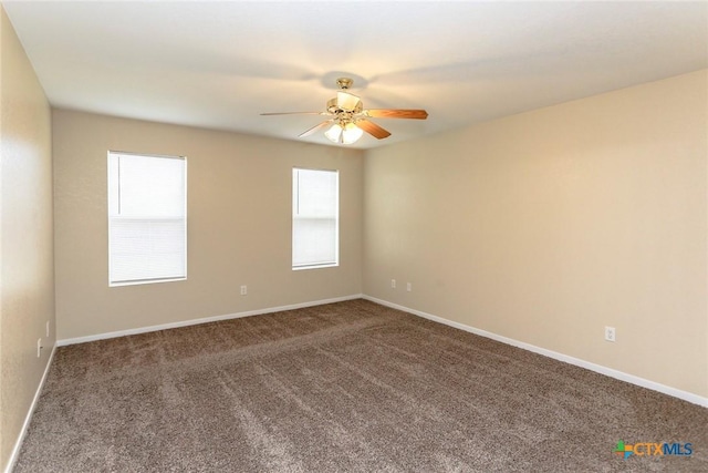 carpeted spare room featuring ceiling fan and a healthy amount of sunlight