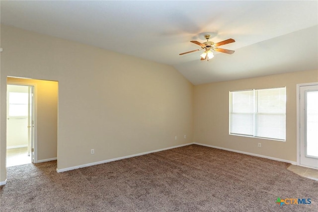 spare room with light colored carpet, vaulted ceiling, and ceiling fan