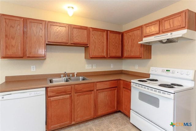 kitchen featuring white appliances, sink, and light tile patterned floors