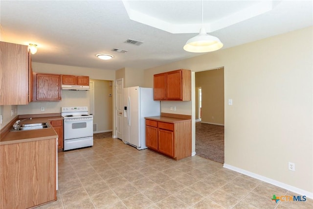 kitchen with white appliances, hanging light fixtures, and sink