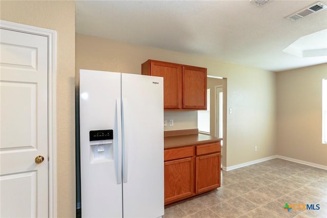 kitchen featuring a wealth of natural light and white fridge with ice dispenser