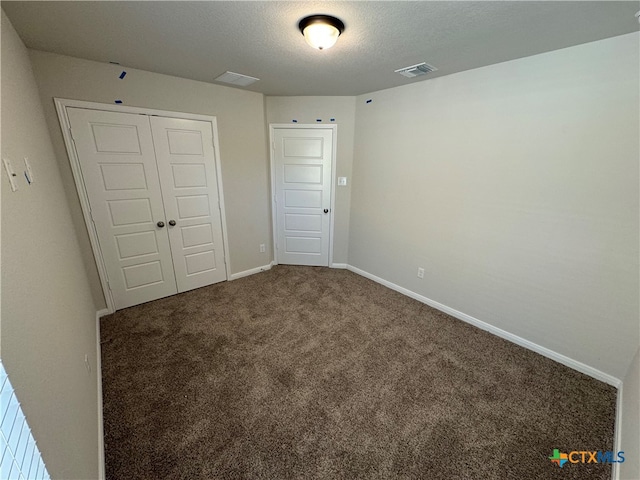 unfurnished bedroom featuring a textured ceiling and carpet floors