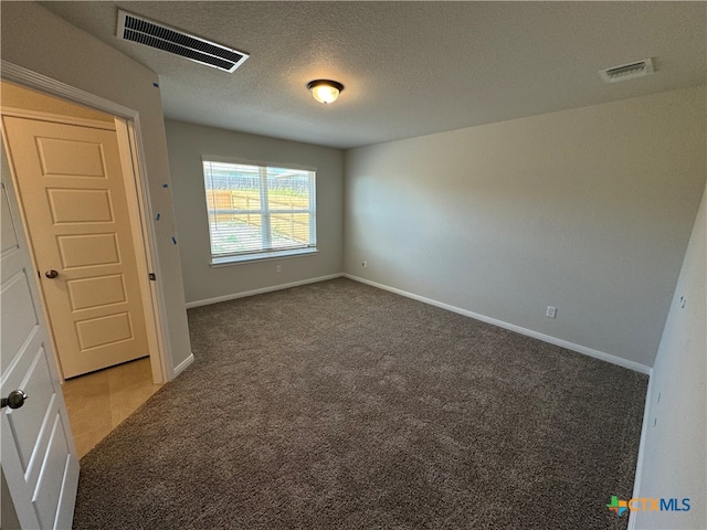 spare room with a textured ceiling and carpet