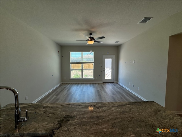 interior space featuring sink, hardwood / wood-style floors, ceiling fan, and a textured ceiling