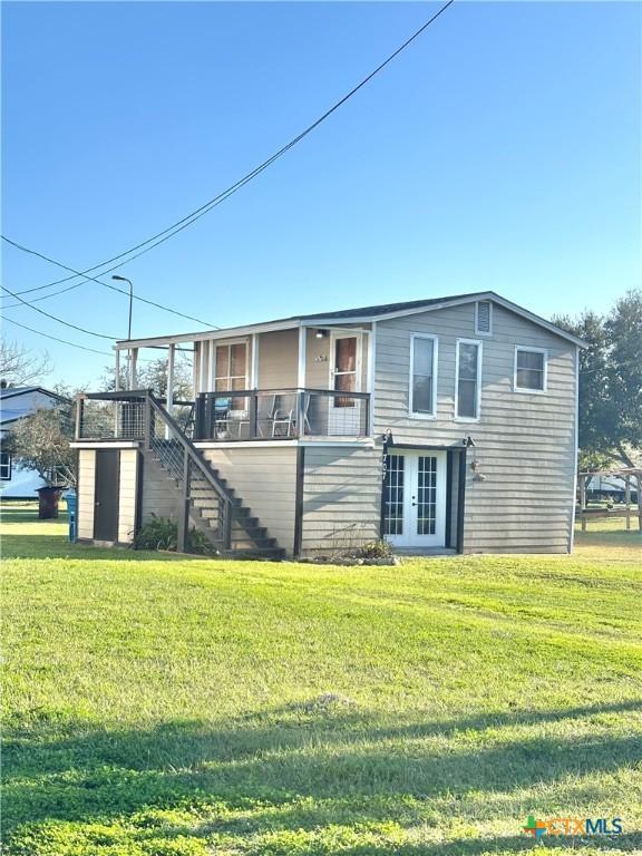 view of front of property with a front yard, french doors, and stairs