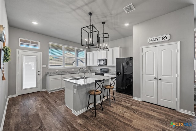 kitchen featuring a kitchen island with sink, sink, white cabinets, and black appliances