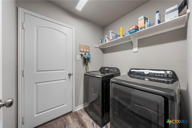 laundry room with dark hardwood / wood-style floors and separate washer and dryer