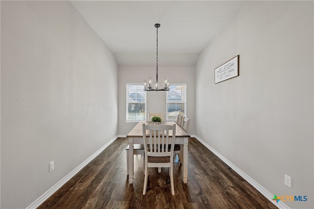 unfurnished dining area featuring dark wood-type flooring and an inviting chandelier