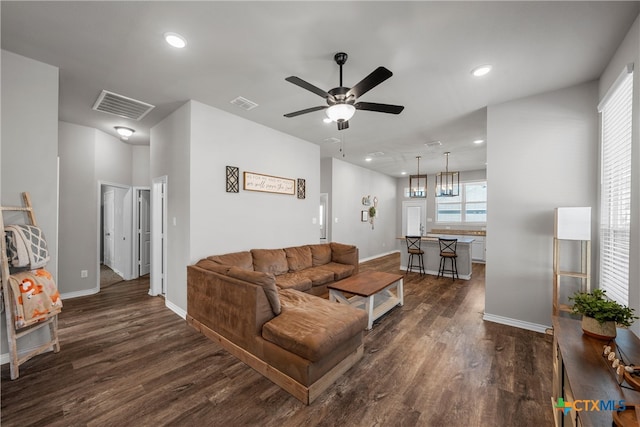 living room featuring ceiling fan and dark wood-type flooring