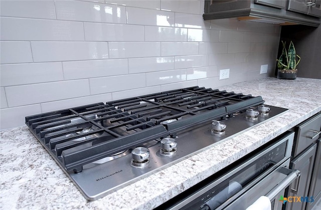 interior details with stainless steel gas cooktop and backsplash