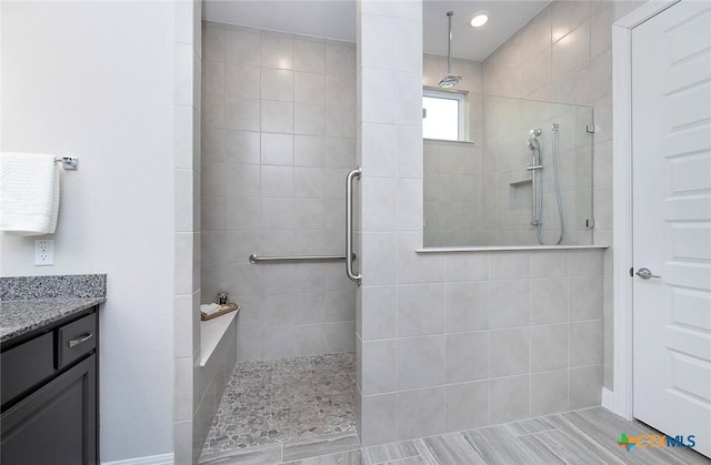 bathroom featuring tiled shower and vanity