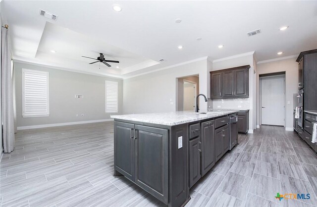 kitchen featuring decorative backsplash, stainless steel appliances, an island with sink, and wall chimney exhaust hood