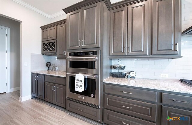 kitchen featuring a tray ceiling, sink, an island with sink, and dark brown cabinets