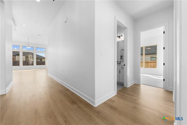 hallway featuring baseboards and wood finished floors