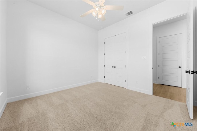 unfurnished bedroom with carpet, visible vents, and baseboards