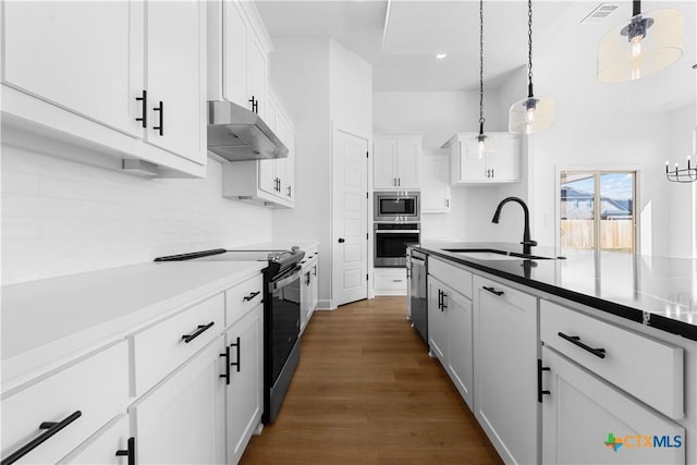 kitchen featuring under cabinet range hood, a sink, visible vents, white cabinets, and appliances with stainless steel finishes