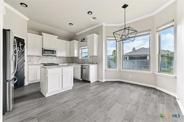606 Juniper Dr, Troy, TX 76579 - kitchen with stainless steel appliances, a chandelier, light wood-type flooring, tasteful backsplash, and ornamental molding