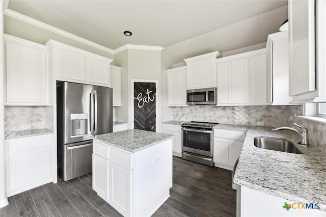 606 Juniper Dr, Troy, TX 76579 - kitchen featuring appliances with stainless steel finishes, a kitchen island, white cabinetry, light stone countertops, and crown molding