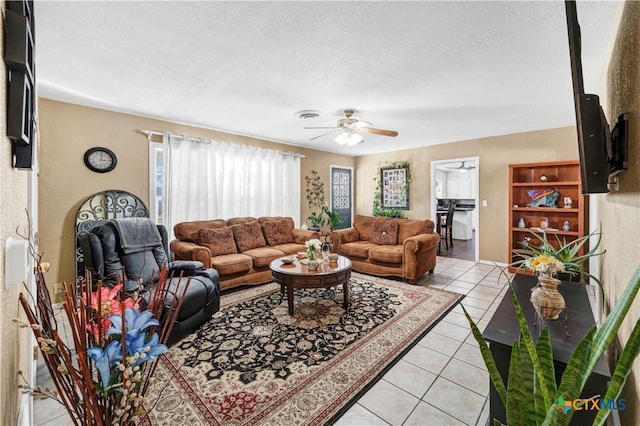 living room featuring light tile patterned floors, a textured ceiling, and ceiling fan