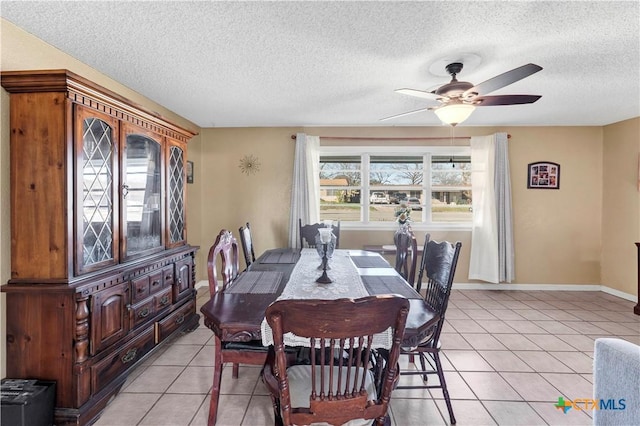 tiled dining room featuring ceiling fan and a textured ceiling