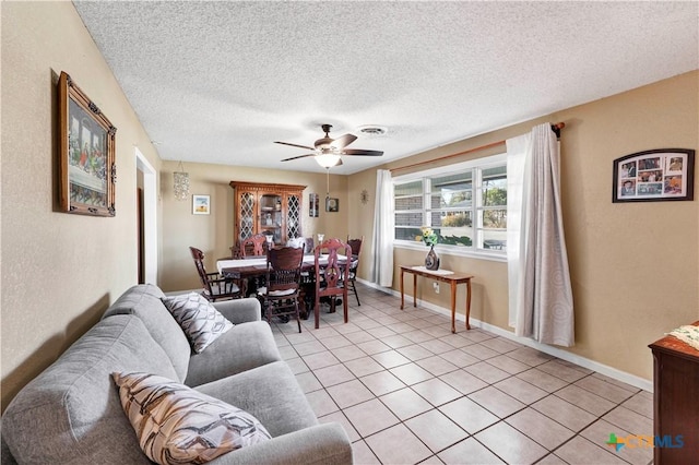 tiled living room with ceiling fan and a textured ceiling