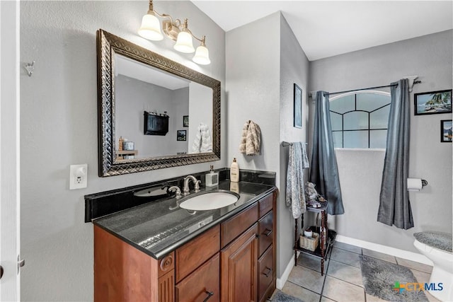 bathroom with tile patterned flooring, vanity, and toilet