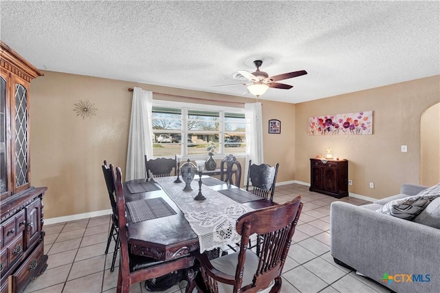 dining space with ceiling fan, light tile patterned flooring, and a textured ceiling