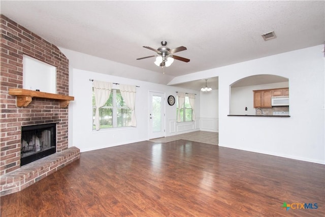 568 Morgans Point Rd, Belton, TX 76513 - unfurnished living room with ceiling fan, wood finished floors, and a brick fireplace