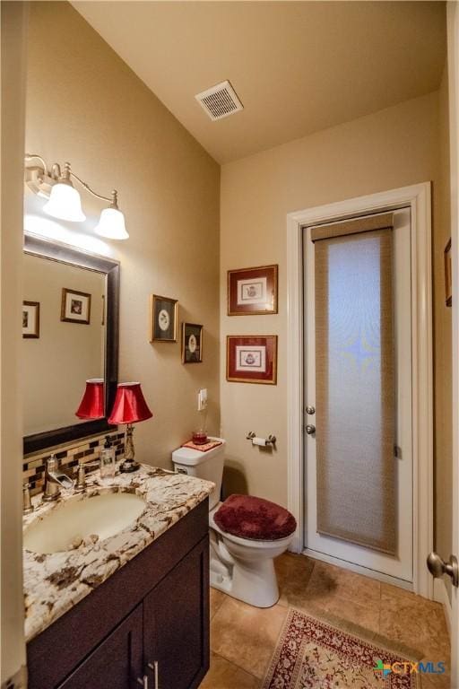 bathroom featuring tile patterned flooring, visible vents, vanity, and toilet