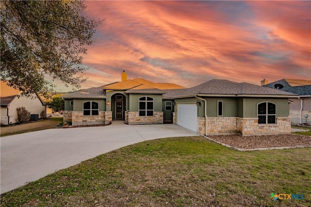 view of front of home featuring a garage, stone siding, a front yard, and stucco siding